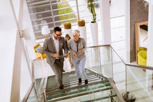 Businessmen And Businesswomen Walking And Taking Stairs In An Office Building