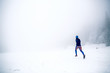 © blas - Trail running woman on snow in winter mountains