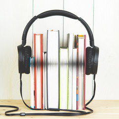 concept of audio book. headphone and books on white background