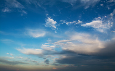 Wall Mural - white curly clouds in a blue sky. sky background sunset