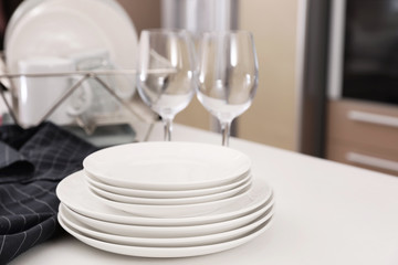 Wall Mural - Stack of clean dishes and glasses on table in kitchen