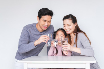 Happy Asian family drinking fresh water for heathly concept