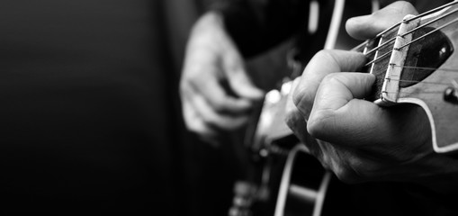 Wall Mural - Guitarist hands and guitar close up. playing electric guitar. copy spaces. black and white.