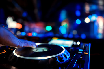 Dj playing the track in the nightclub at a party. In the background laser light show