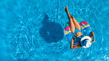 Aerial Top View Of Beautiful Girl In Swimming Pool From Above, Relax Swim On Inflatable Ring Donut And Has Fun In Water On Family Vacation
