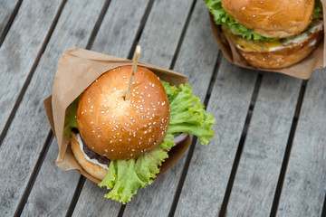 two burgers on a wooden table in a cafe