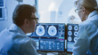 © Gorodenkoff - In Control Room Doctor and Radiologist Discuss Diagnosis while Watching Procedure and Monitors Showing Brain Scans Results, In the Background Patient Undergoes MRI or CT Scan Procedure.