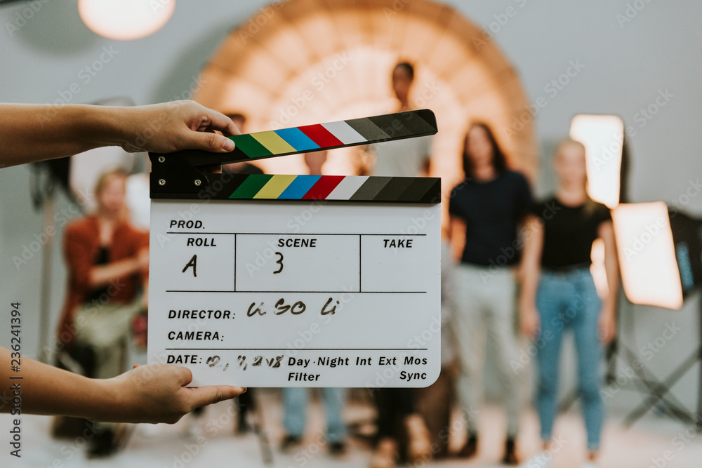Woman holding a movie production clapperboard - obrazy, fototapety, plakaty 