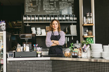 Portrait of barista behind counter in cafe