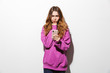 © Drobot Dean - Portrait of displeased woman 20s wearing sweatshirt using smartphone while standing, isolated over white background