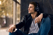 © Goran - Hipster man enjoying while listening music on headphones