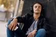 © Goran - Young hipster using MP3 player and listening to music