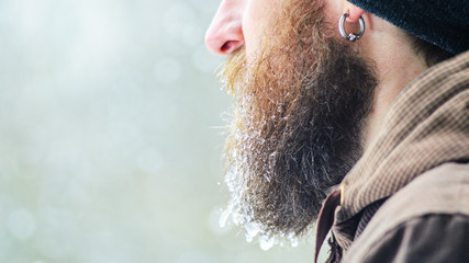 Wall Mural - Beard covered with icicles and frozen droplets. Young man winter portrait in profile.