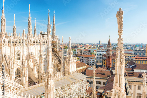 Obraz na plátne  White statue on top of Duomo cathedral and view to city of Milan
