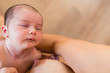 Newborn baby resting after breastfeed and feeding on his mother breast