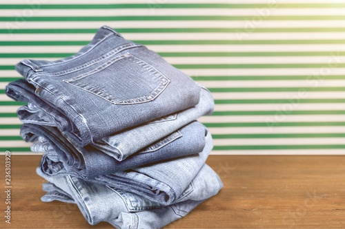 Tela Pile of blue jeans over white background