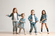 © master1305 - The portrait of cute little kids boy and girls in stylish jeans clothes looking at camera against white studio wall. Kids fashion and happy emotions concept