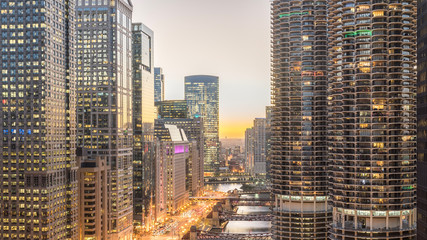 Wall Mural - Aerial view of skyline along Chicago river through downtown at sunset