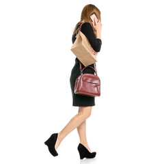 Wall Mural - Beautiful woman in a dress business with bag package takeaway, smartphone in hand goes on a white background back view isolation