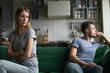 © fizkes - Offended upset man and woman sitting separately on couch, sofa in living room, wife looking with insult at husband, bad relationships, quarrel, break up