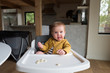 © Rennie Solis - Portrait of baby sitting in high chair