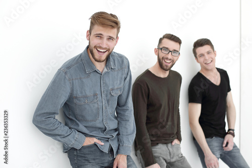 Fotografía three people leaning against the wall, smiling