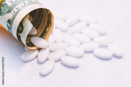 Foto money and pills in pill bottle and stethoscope on table medical expense concept