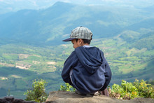 Asian Boys Sit On The Rock See The Mountains And The Sky At Phu Rua National Park In Loei, Thailand.