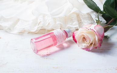 Wall Mural - perfumed rose water in a bottle on a wooden table