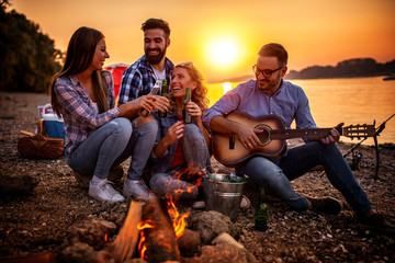 Poster - Friends having picnic around the fire