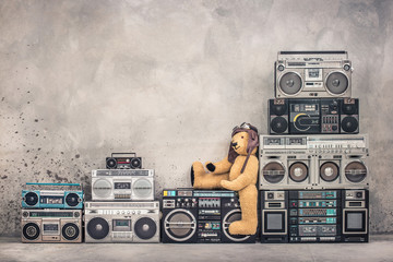 Wall Mural - teddy bear toy with leather aviator's hat and goggles sitting on retro old school design ghetto blas