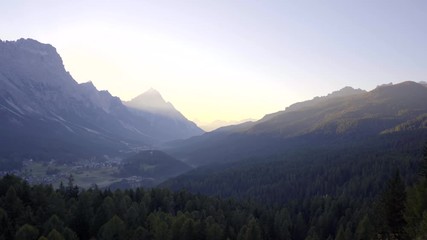 Wall Mural - Scenic sunrise over Italian Dolomites near Cortina d'Ampezzo. Early morning shot of autumn mountains with colorful trees in first rays of sunlight.