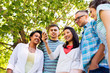 © Syda Productions - friendship, technology and international concept - group of friends with smartphone at summer park