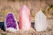 Golden Triangle gemstones: amethyst, rose quartz and white quartz, standing together in the grass
