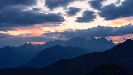 Wall Mural - Time Lapse footage of colorful sunset in Italian Dolomites with dramatic sky scape full of clouds turning orange to black.