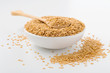 Golden flaxseed in wooden spoon and bowl on white background