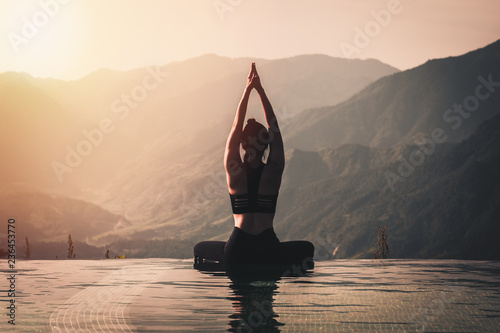 Cuadros en Lienzo Beautiful Attractive Asian woman practice yoga Lotus pose on the pool above the