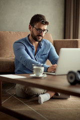 Working home concept -man using a laptop computer for work at home.