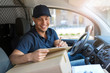© pikselstock - Delivery man sitting in a delivery van