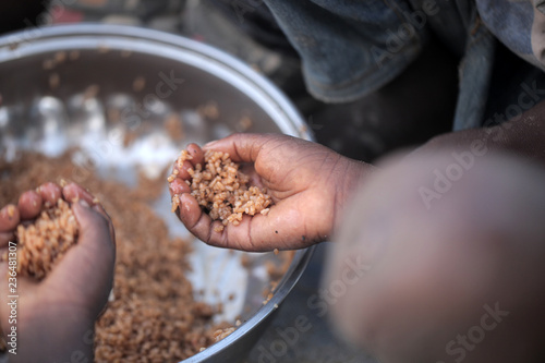 Fotografía kids eating brown rice and fish in Africa - closeup