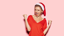 Portrait Of Happy And Excited Young Girl Looking Stylish In Christmas Festive Outfit. Holiday And Xmas Concept. Cheerful Model In Good Mood Indoors On Pink Background