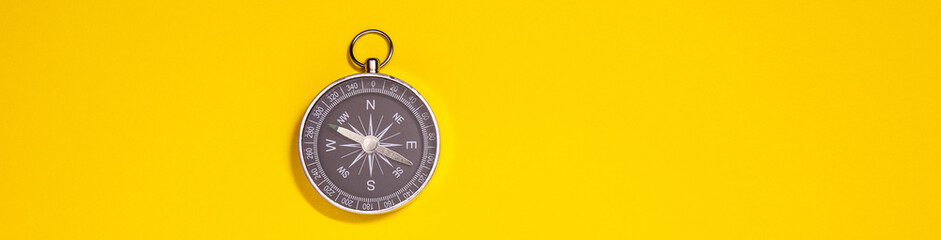 black compass on yellow background, travel concept