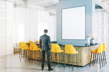 White bar corner, yellow stools and poster, man