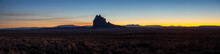 Dramatic Panoramic Landscape View Of A Dry Desert With A Mountain Peak In The Background During A Vibrant Sunset. Taken At Shiprock, New Mexico, United States.