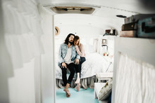 Cute Hipster Couple Cuddling In Converted School Bus Tiny Home