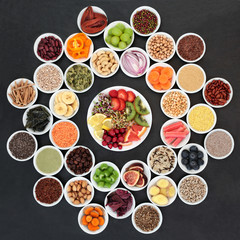  Super food for losing weight concept including fruit, vegetables, grains, nuts, seeds, spices, coffee, supplement powders,  and herbs on slate background. 