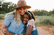 © Erin Drago Photography/Stocksy - Multi-race mom and daughter, together in a field, smiling