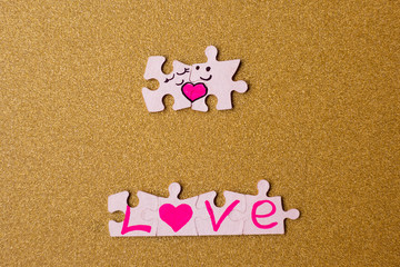 Wall Mural - Valentine's day concept. couple of puzzles with hearts on a gold background. copy space. selective focus.