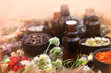 Essential Oil Bottles On Medicinal Flowers And Herbs Background, Selective Focus, Toned