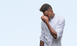 © Krakenimages.com - Young african american man over isolated background tired rubbing nose and eyes feeling fatigue and headache. Stress and frustration concept.